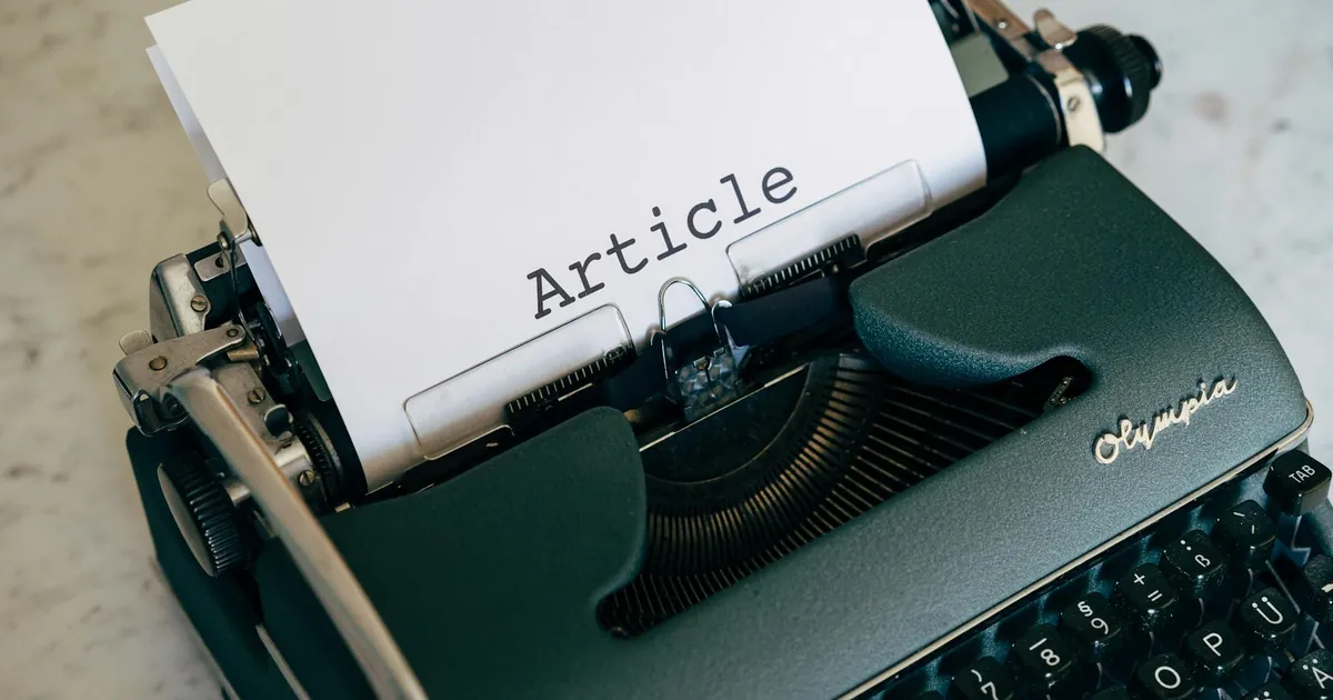 Close-up of a vintage typewriter with a paper sheet displaying 'Article' in retro font.