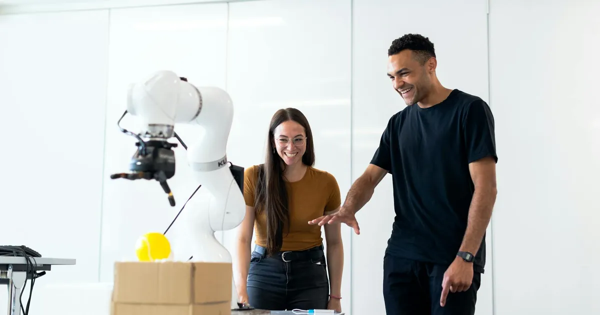 Two engineers collaborating on testing a futuristic robotic prototype in a modern indoor lab.