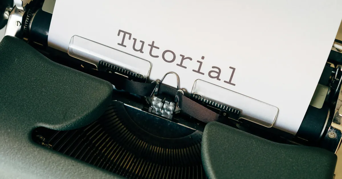 Close-up shot of a vintage typewriter with the word 'Tutorial' typed on paper.