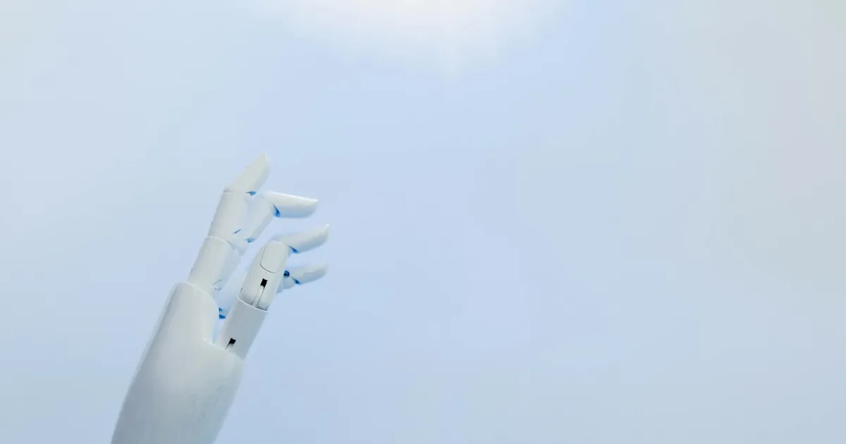 A robotic hand reaching towards a bright light on a white background symbolizing innovation.