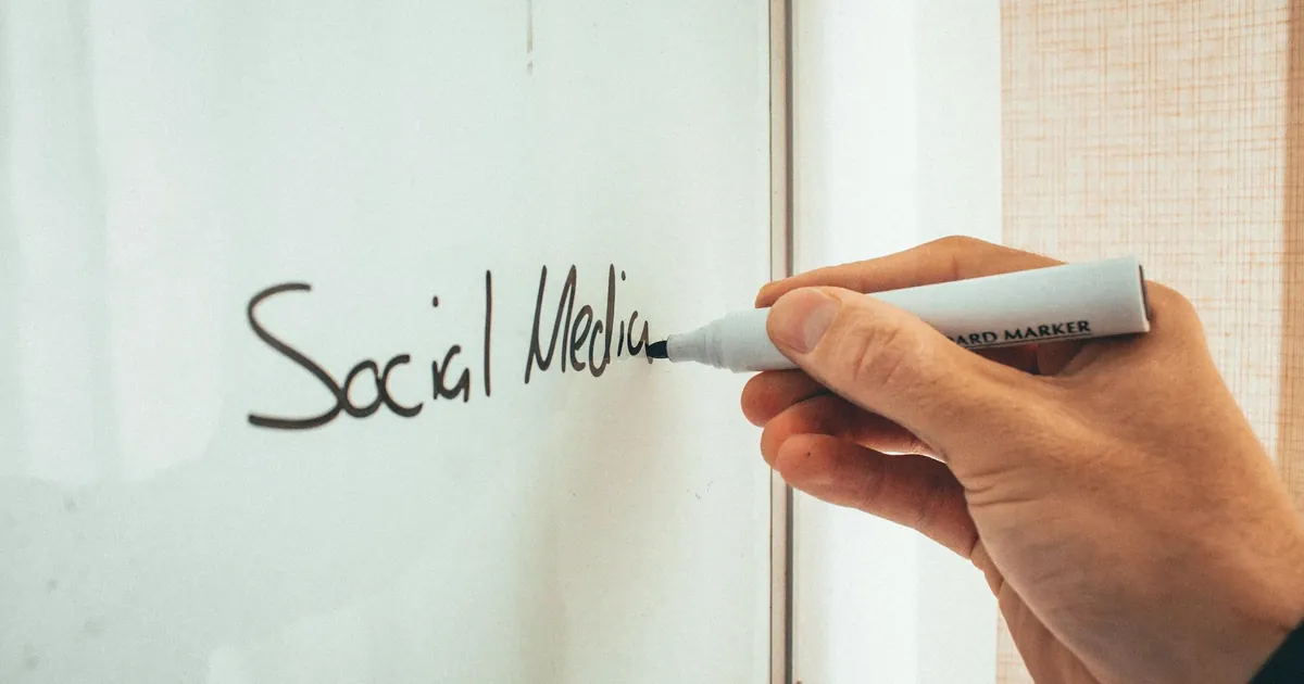 Crop anonymous male teacher writing on whiteboard with marker during social media training courses
