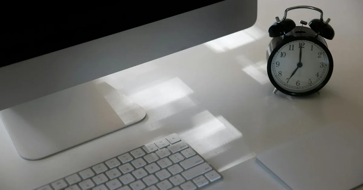 Elevate productivity with a sleek workspace featuring a computer, keyboard, and analogue clock.